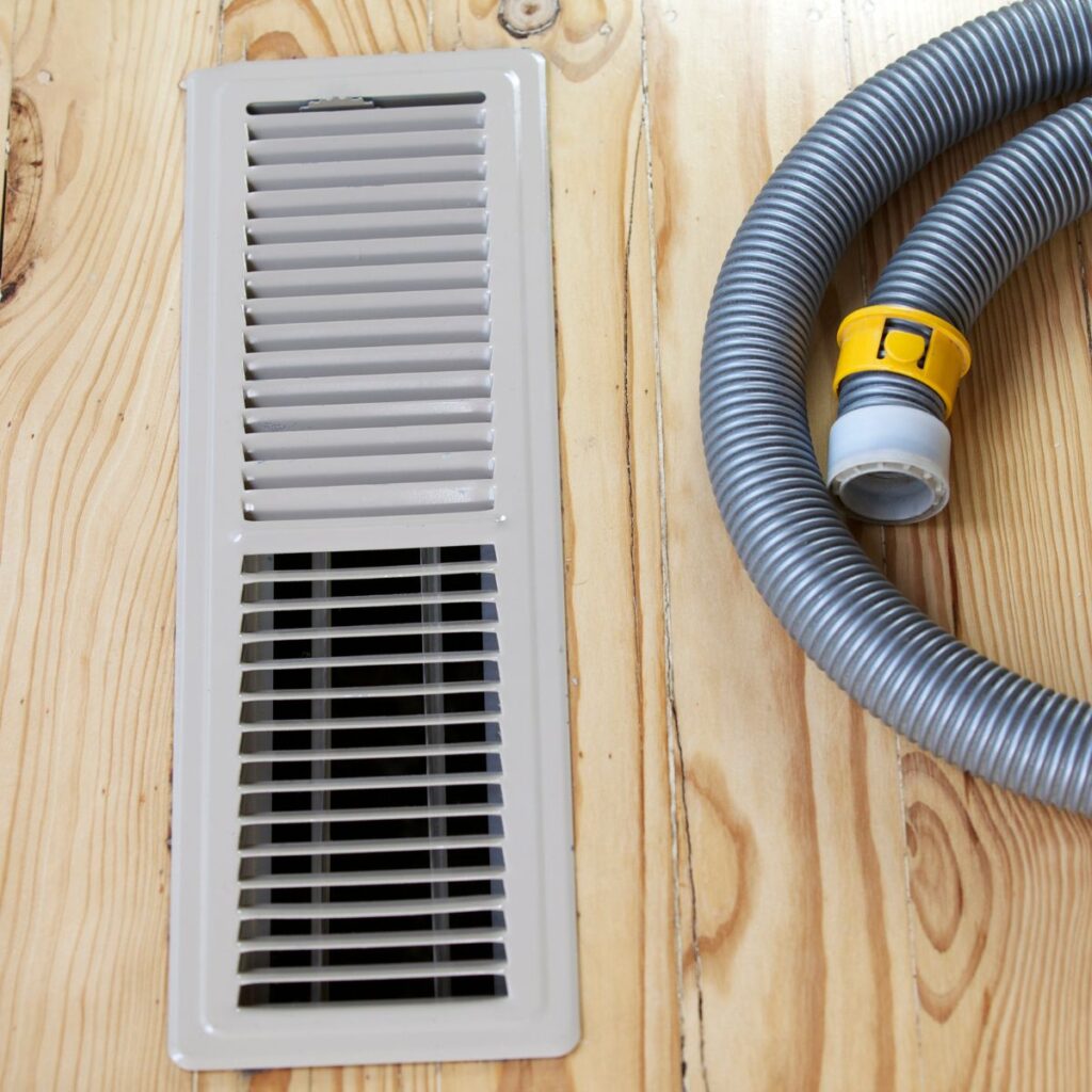 air duct with a vacuum hose next to it