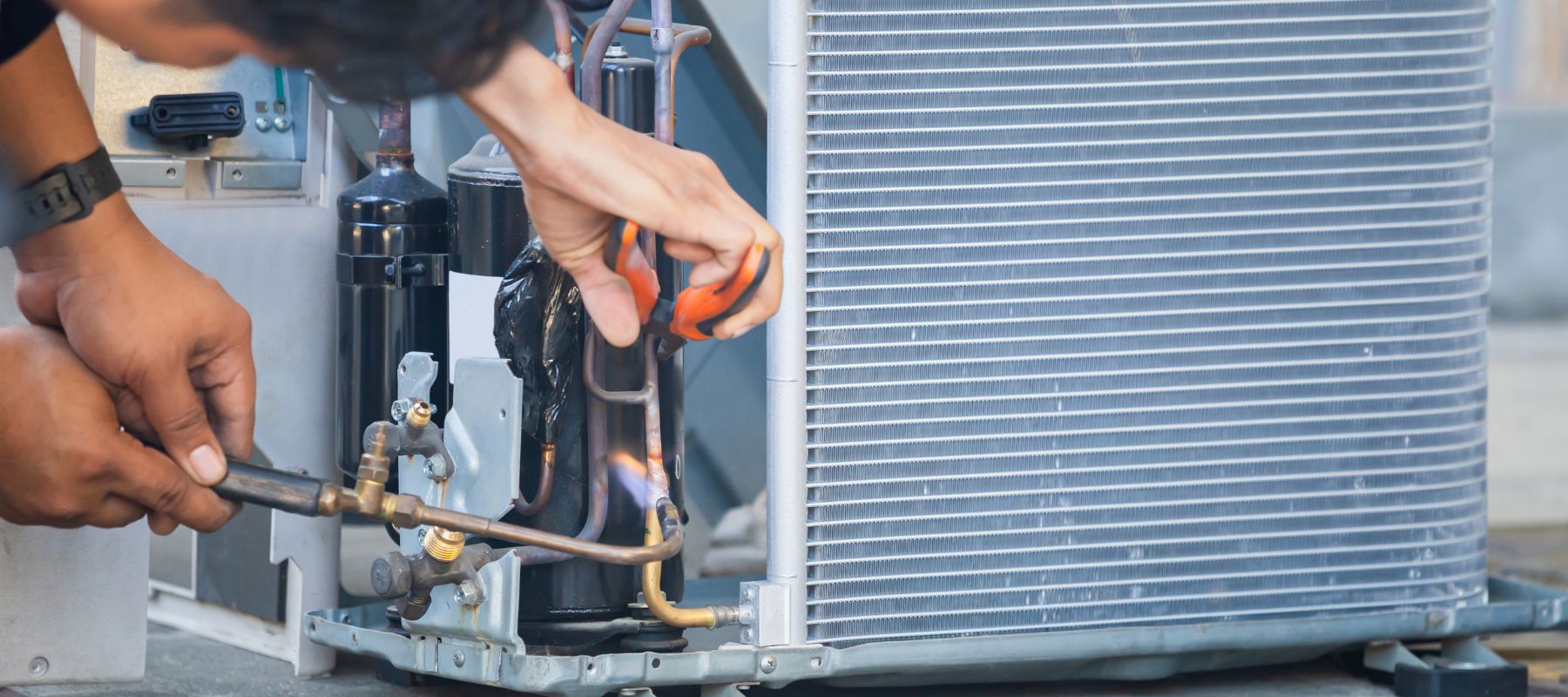 hvac tech using a tool to work on copper piping