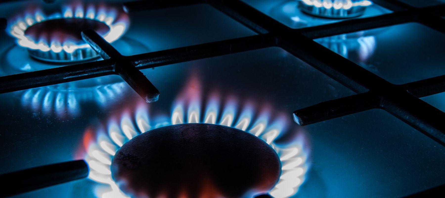 Gas stove burners with blue flames, showcasing energy-efficient cooking