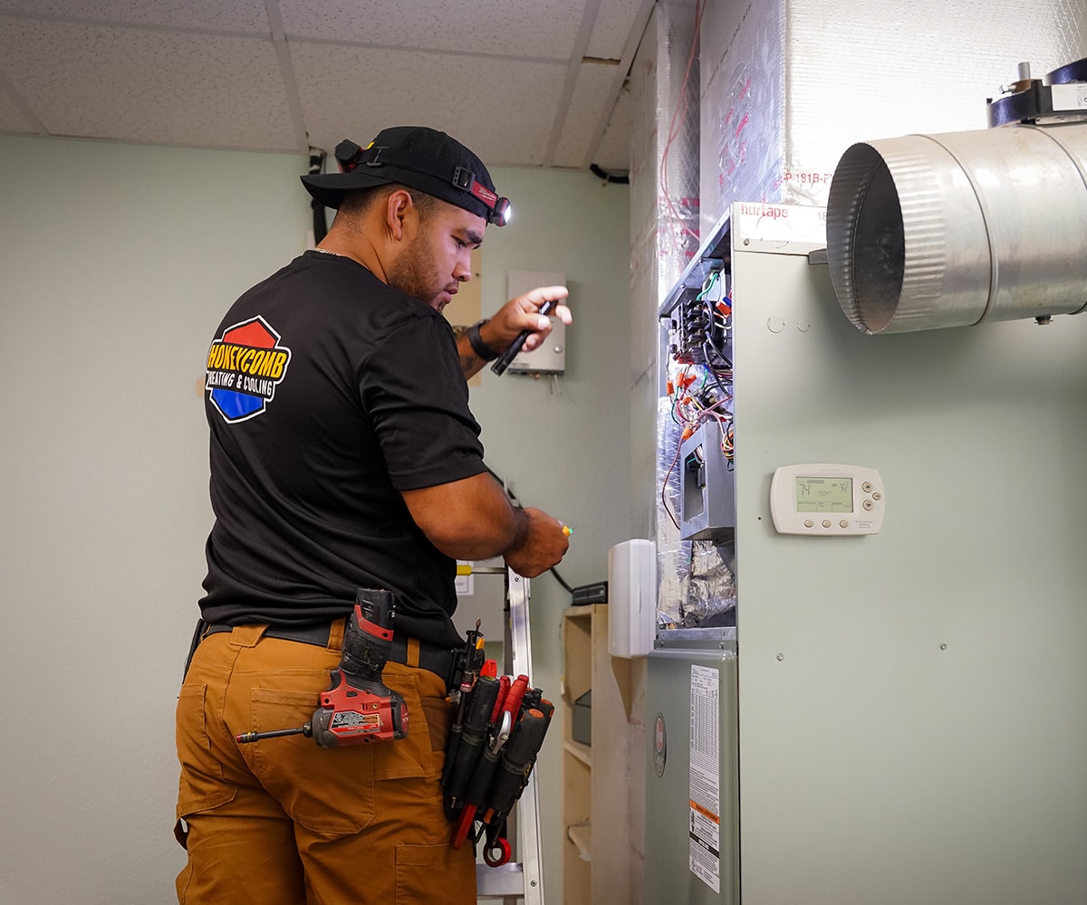 Honeycomb technician inspecting furnace with light