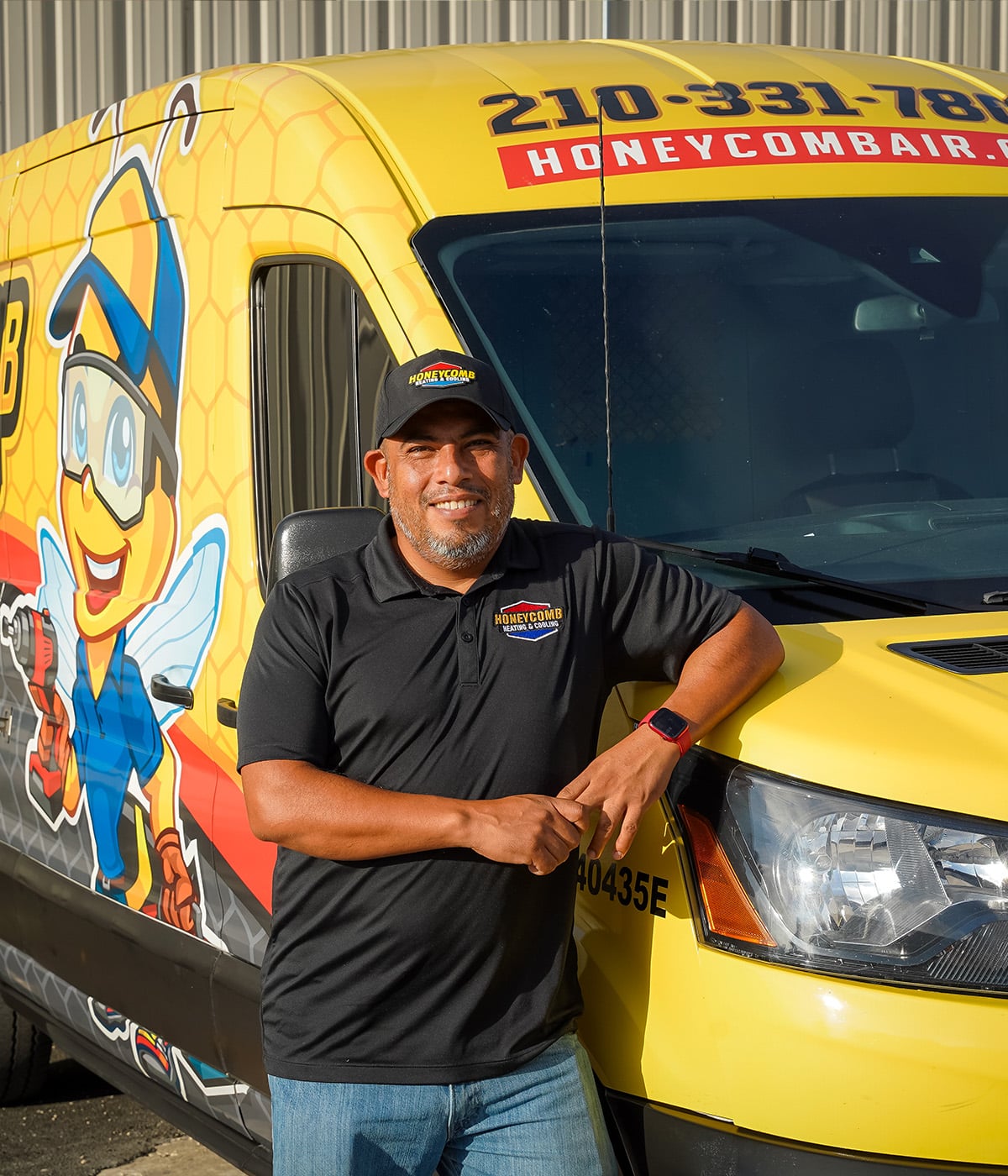 Team member of Honeycomb standing confidently beside a yellow van with a bee illustration