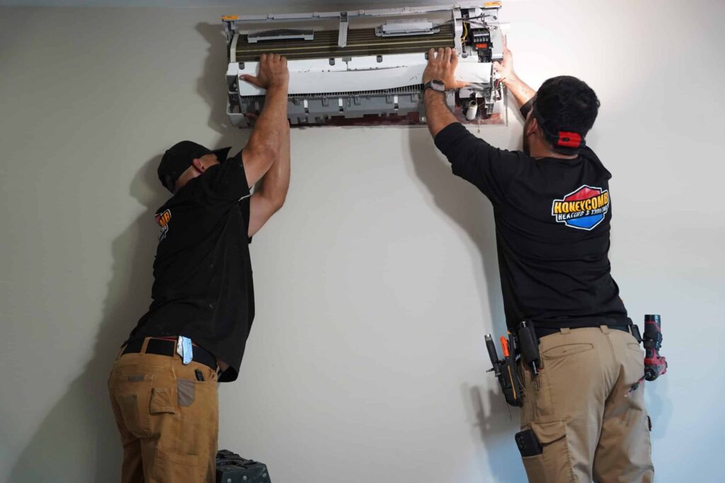 Honeycomb Heating & Cooling technicians installing a ductless AC mini-split unit in a Live Oak TX home