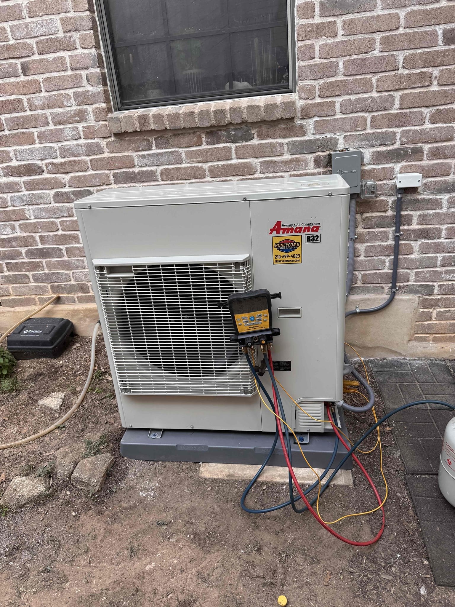HVAC technician performing inverter AC installation on an outdoor condensing unit in San Antonio, TX